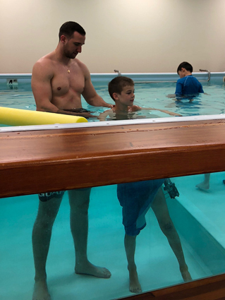 Preston wearing an external fixator while doing hydrotherapy with a physical therapist at the Rubin Institute's Rehabilitation Department