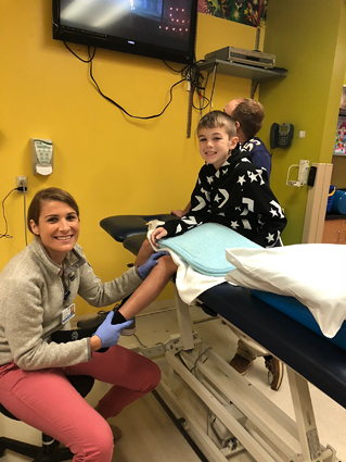 Preston with a physical therapist having his leg checked at the Rubin Institute's Rehabilitation Department