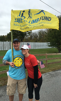 Rachael and Dr. Standard with Save-A-Limb flag at walk event