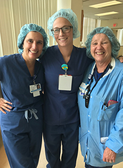 Rachael in scrubs with RIAO nurses during a shadowing visit