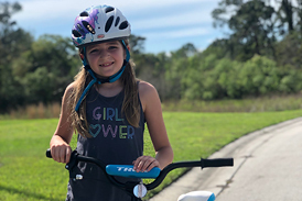 Emma in a Girl Power t-shirt and helmet with a bicycle