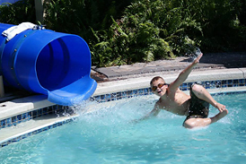 Matt in midair shooting out of a swimming pool tube slide before his second surgery