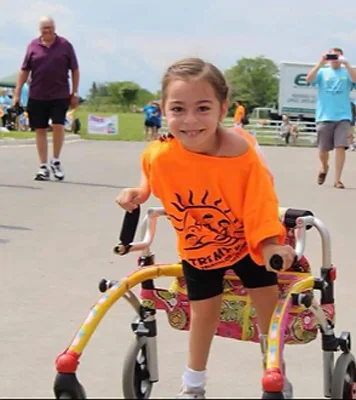 Alena participating in a triathalon with her wheeled-gait trainer walking aid