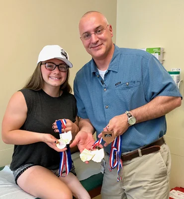 Brooklynn with Dr. Standard showing off all her gold medals
