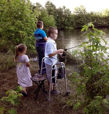 Wyatt fishing at a lake while using a walker