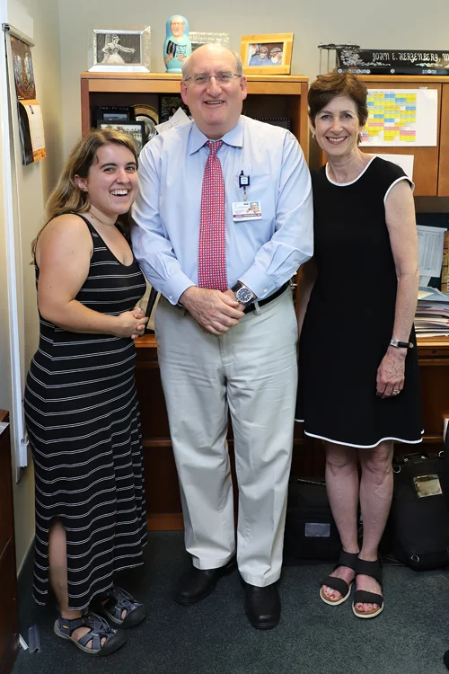 Hannah and her mother standing with Dr. Herzenberg in 2018; Hannah now reaches much higher than her mother's shoulders--closer to the height of her mother's nose.