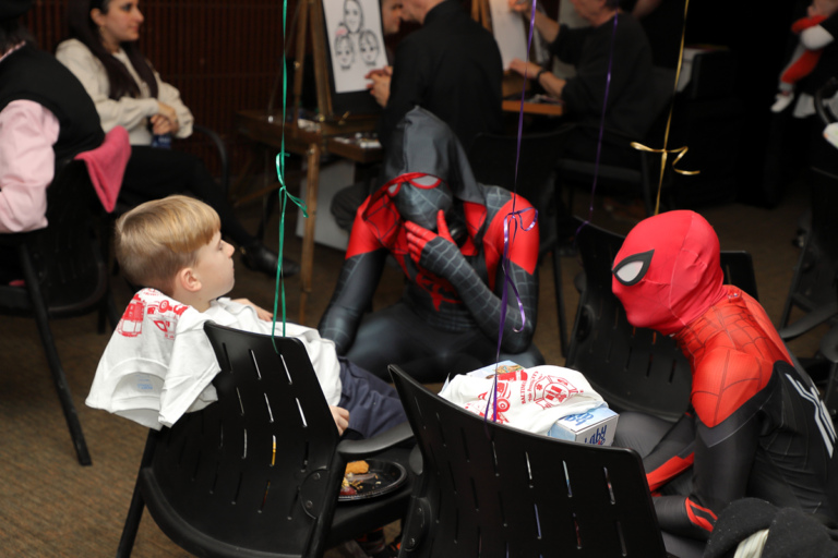 Boy sitting being visited by Spidermen