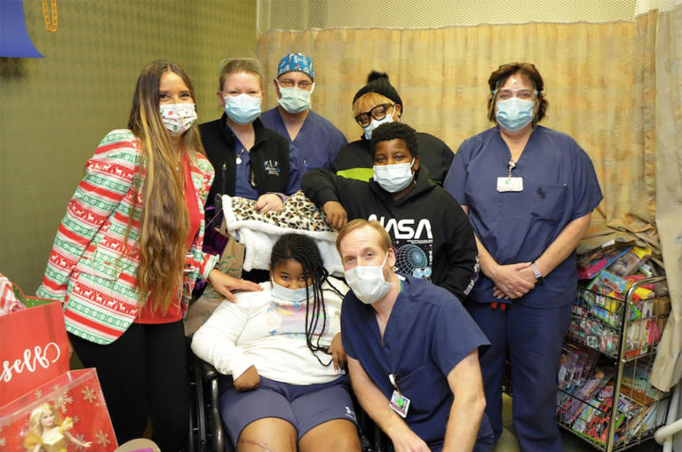 Dillan with her family, Dr. Standard, and other International Center for Limb Lengthening staff with the presents that she donated