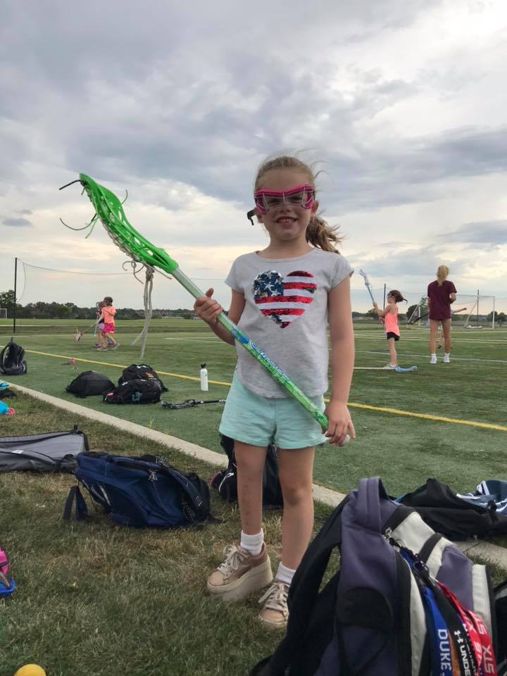 Charlotte dressed in gear for Lacrosse camp with a shoe lift