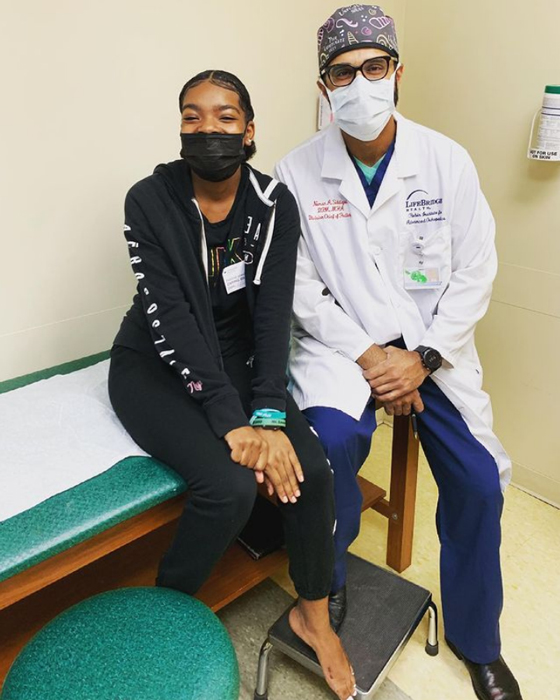 A girl with Dr. Noman Siddiqui after being treated for brachymetatarsia and a bunion