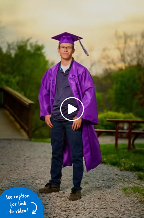 A boy wearing a purple graduation cap and gown while standing outside