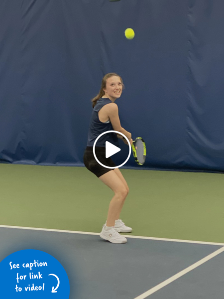 A girl swinging a tennis racket at a tennis ball