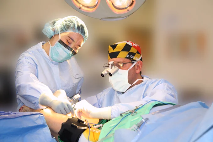 Dr. Christopher Bibbo performing flap surgery in the operating room with a fellow