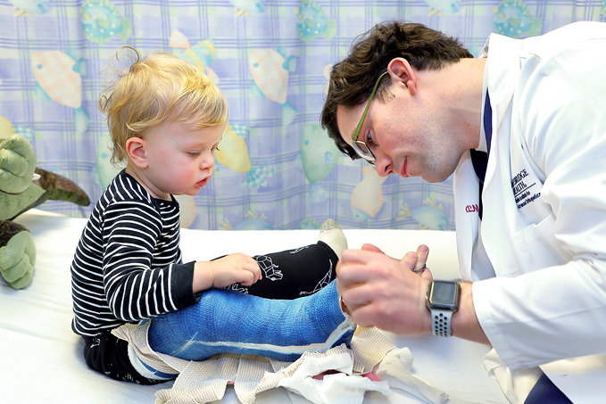 Dr. Philip McClure removing a child's cast