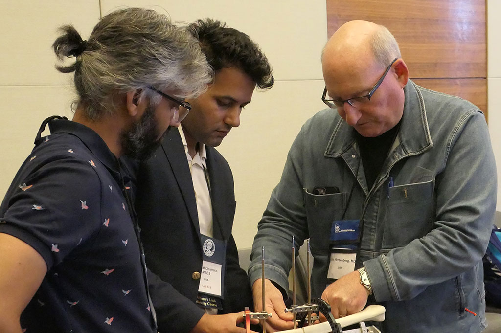  Dr. John Herzenberg working with two participants in a sawbone lab