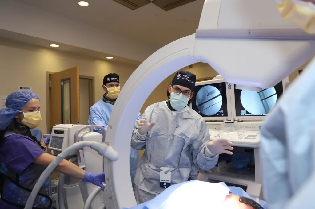 Dr. Philip McClure teaching students how to perform a procedure during a cadaver lab