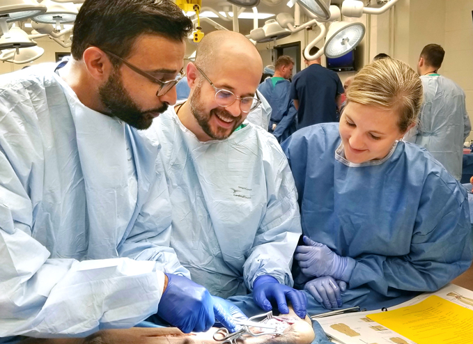 Dr. Noman Siddiqui teaching students how to perform a procedure during a cadaver lab