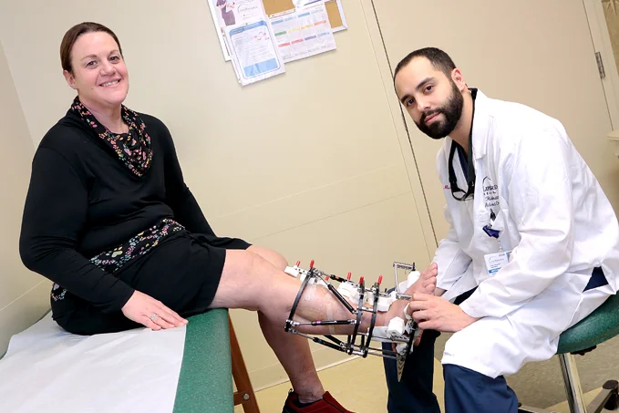 Dr. Michael Assayag treating a patient who has an external fixator on her leg at the International Center for Limb Lengthening