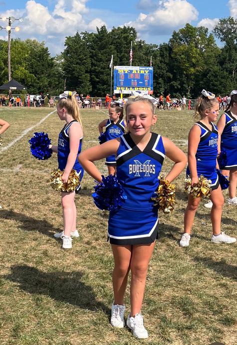 Ally cheerleading at a game on the field