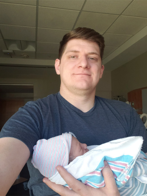 Andrew holding his newborn son
