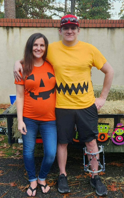Andrew wearing an external fixator standing with his wife in Halloween costumes
