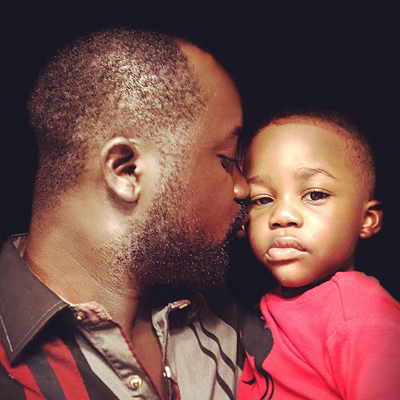 Close up of Ebou kissing his young son