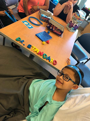 JJ spelling out Dr. Standard's name in Play-doh on a hospital table