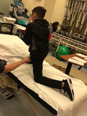 JJ stretching on a physical therapy table