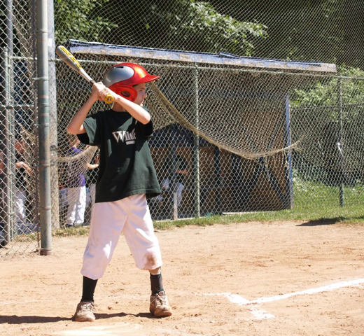 Jack holding a baseball bat ready to hit a baseball