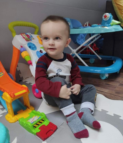 Kacper sitting with toys after treatment for club hand