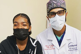 Kamryn and Dr. Noman Siddiqui wearing masks and smiling while sitting next to each other