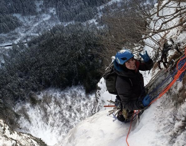 Keagan climbing up the side of a mountain in the snow