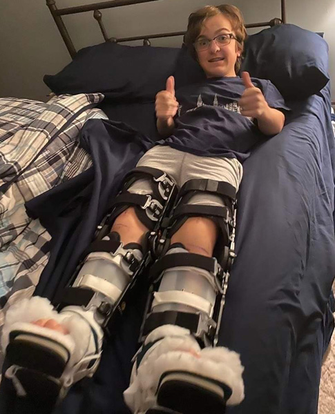 Preston lying in bed with braces on his legs