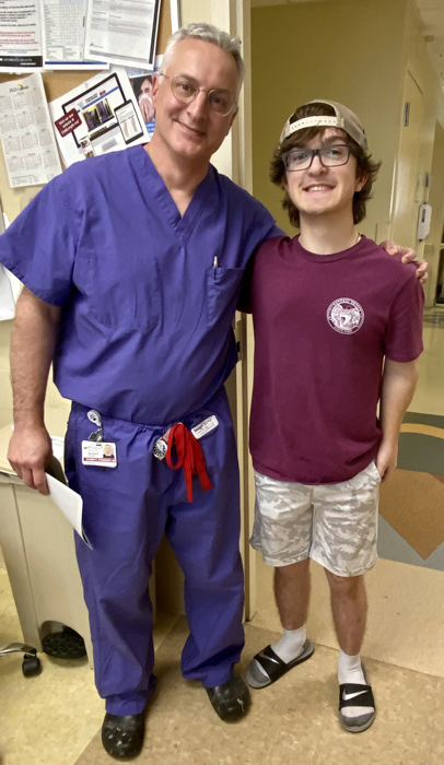 Preston standing smiling with Dr. Standard at his treatment completion