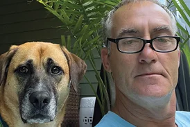 Steve with his dog next to a potted plant