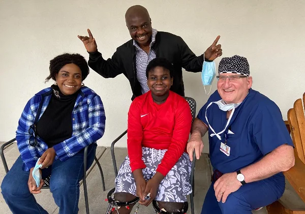 Success Nworisa and his family smiling with Dr. John Herzenberg