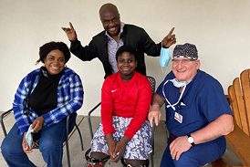 Success Nworisa and his family smiling with Dr. John Herzenberg