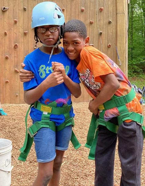 Sudan and a girl in front of an outdoor rock climbing wall