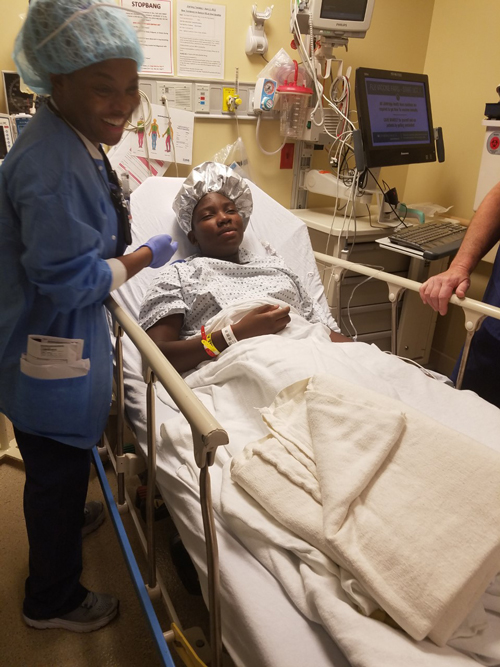 Zuri in a hospital bed with his mother awaiting surgery