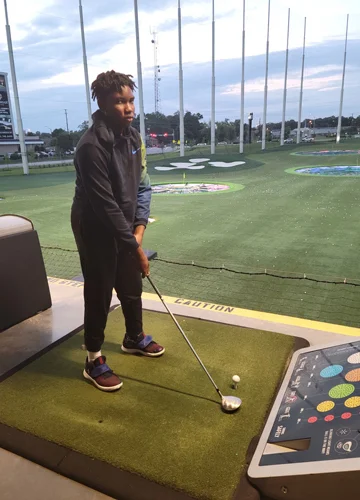 Zuri practicing at a golf putting range