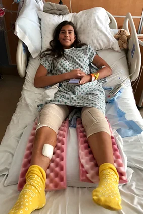 Cassidy as a girl in a hospital bed recuperating after a procedure