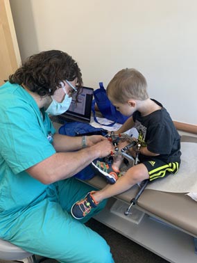 Jackson as a young boy helping Dr. McClure with an external fixator strut adjustment