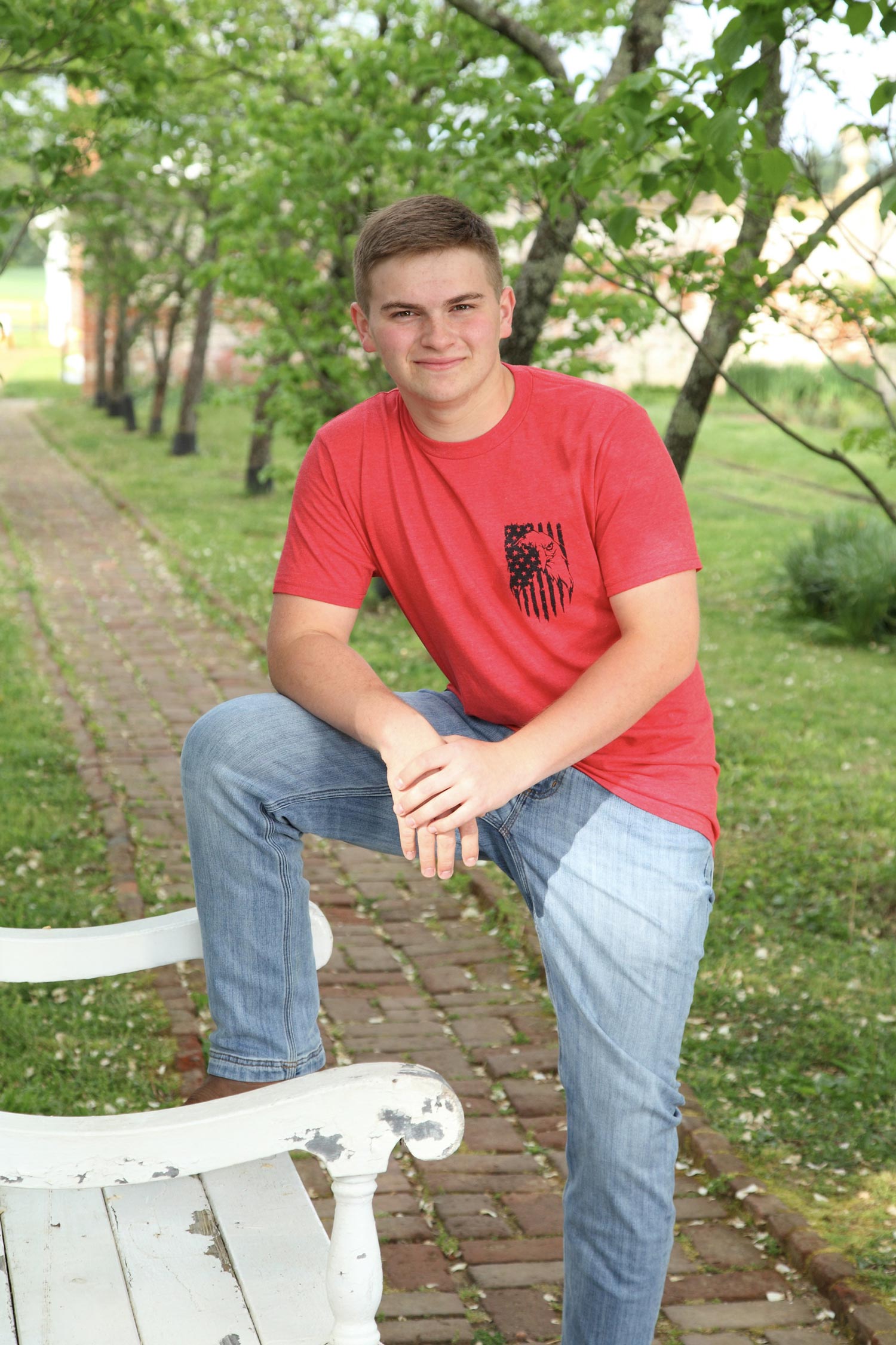 Matthew as an adult standing with one foot on a bench